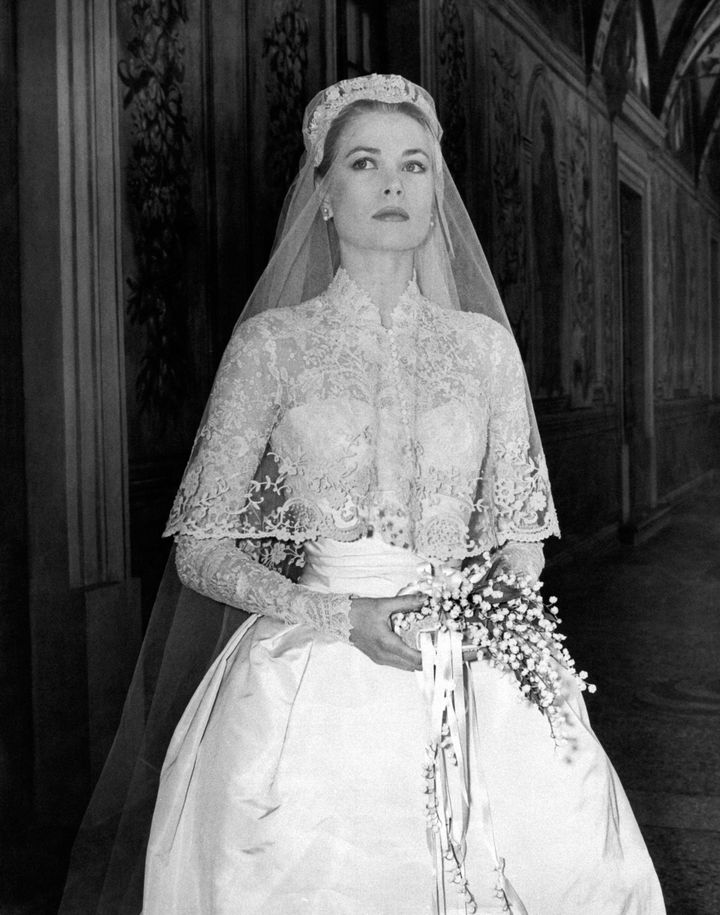 Η πριγκίπισσα του Μονακό, Γκρέις Κέλι, με κομψό δαντελένιο νυφικό που περιγράφει τη σιλουέτα της και περίτεχνο πέπλο, στο γάμο της με τον πρίγκιπα Ρενιέ Γ΄ του Μονακό, το 1956.