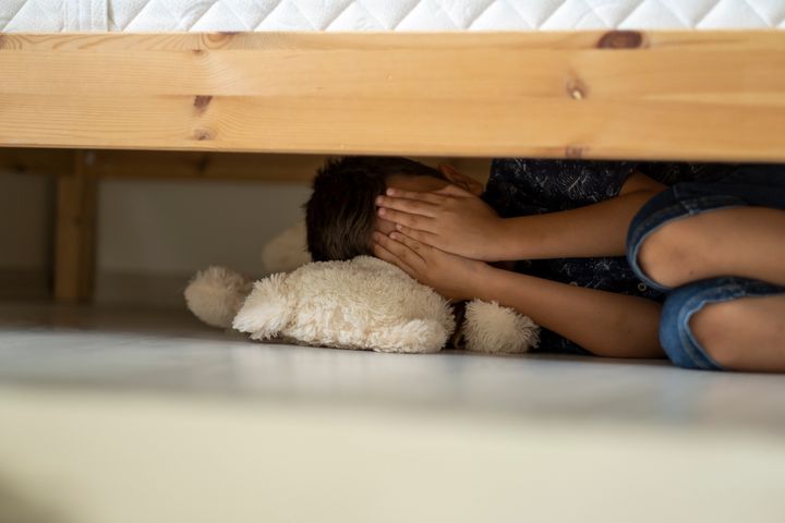 Child hiding under the bed