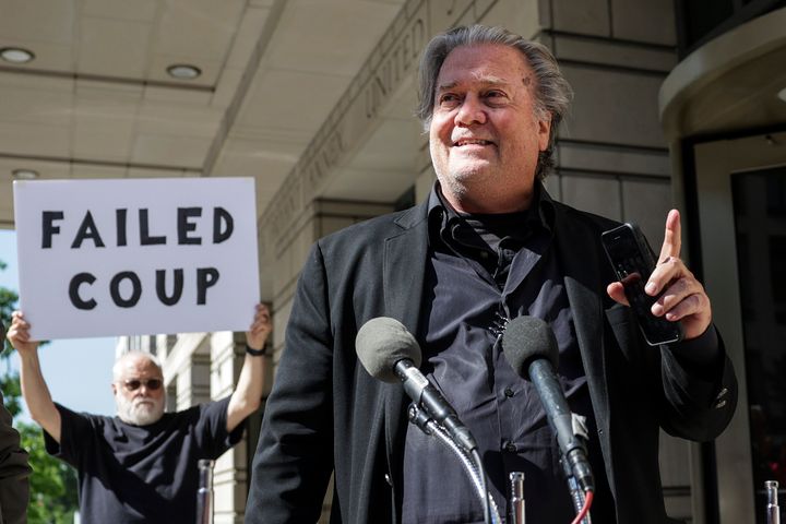 Steve Bannon, advisor to former President Donald Trump, speaks to the media as a protester stands behind him, outside of the E. Barrett Prettyman U.S. Courthouse on June 15 in Washington, D.C.