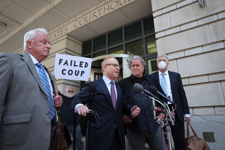 Activist Bill Christeson is seen in the back holding a sign reading "Failed Coup."