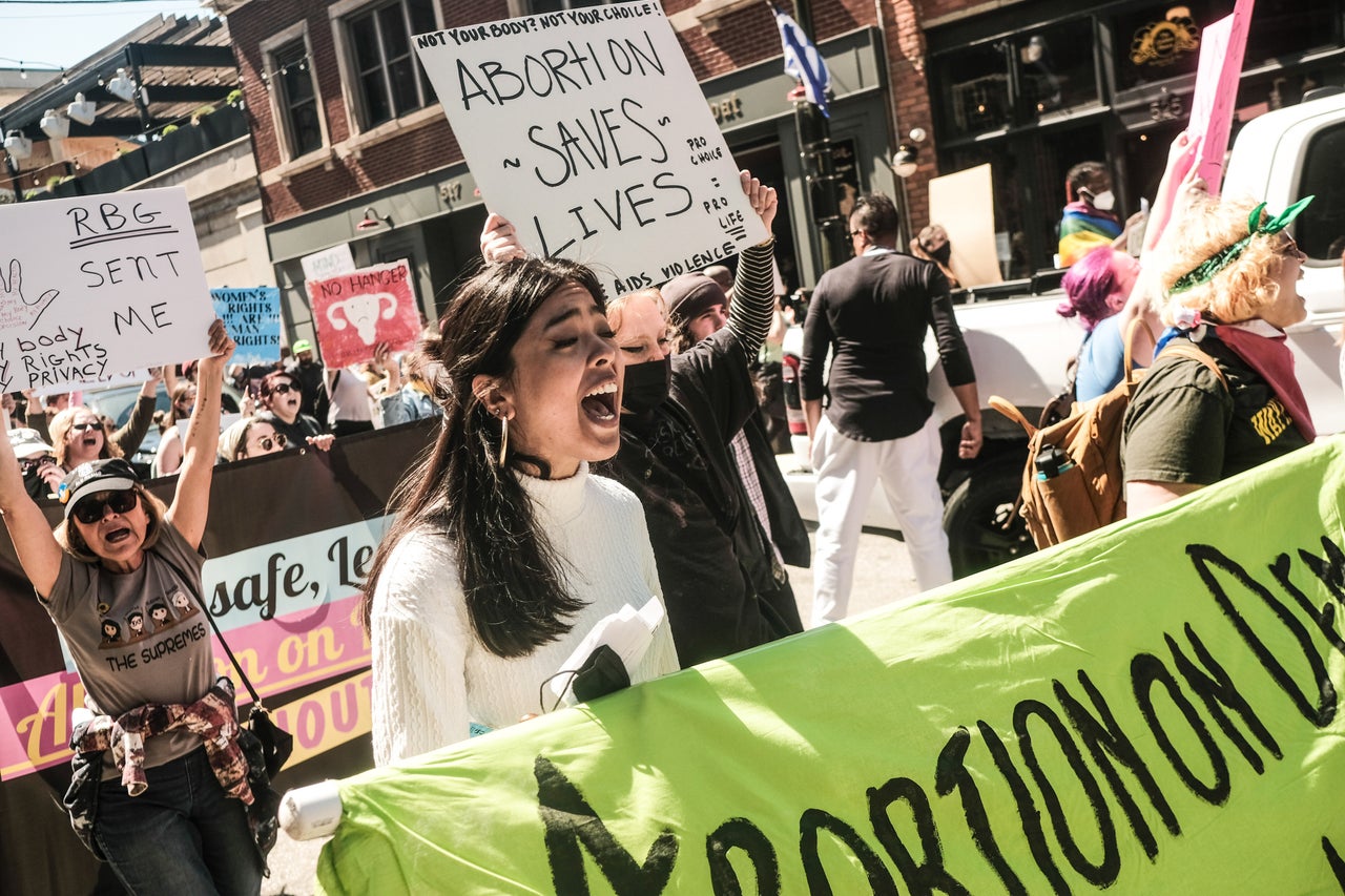 Protesters hold placards, chant and march through downtown Detroit in support of Roe v. Wade.