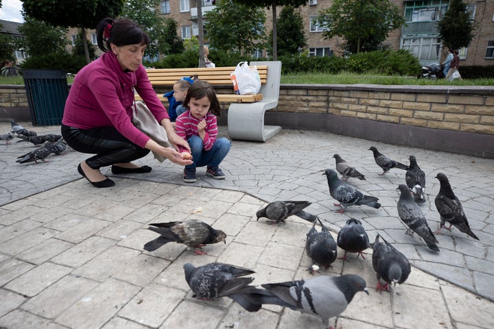 Una mujer que juega con sus hijos en la plaza de Bucha.