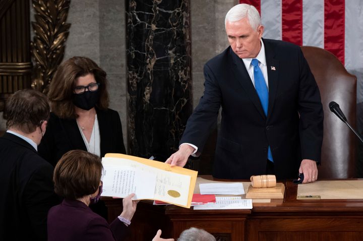 Then-Vice President Mike Pence hands the electoral certificate from the state of Arizona to Sen. Amy Klobuchar, D-Minn., as he presides over a joint session of Congress as it convenes to count the Electoral College votes cast in November's election, at the Capitol in Washington, Jan. 6, 2021. Pence won’t be testifying at Thursday’s Jan. 6 committee hearing.