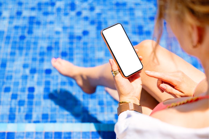 Una mujer utilizando un móvil en una piscina.