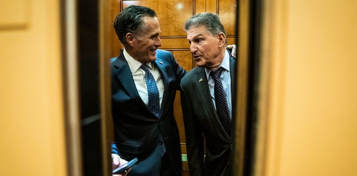 Sen. Joe Manchin (D-W.Va.) and Sen. Mitt Romney (R-Utah), head to a vote as senators make their way to a briefing on the war in Ukraine on Capitol Hill on Wednesday, March 30 in Washington, D.C.