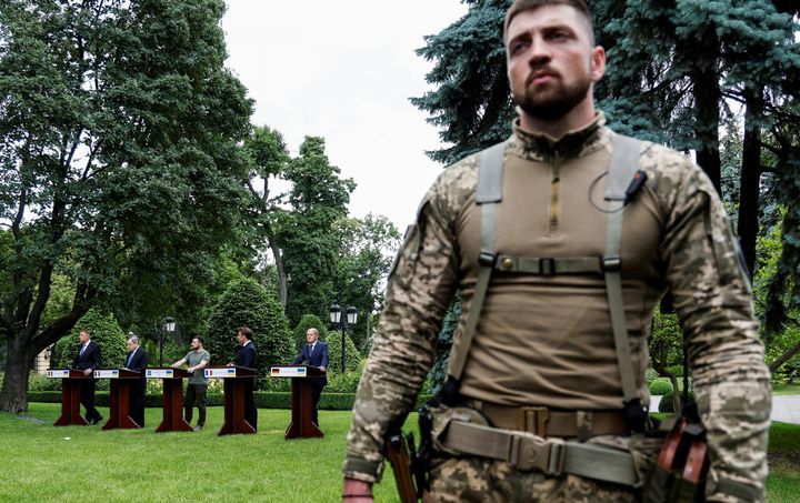 16 Ιουνίου 2022. Οι πέντε ηγέτες στο φόντο, ενώ σε πρώτο πλάνο διακρίνεται ένοπλος Ουκρανός στρατιώτης κατά τη διάρκεια της κοινής συνέντευξης Τύπου. REUTERS/Valentyn Ogirenko