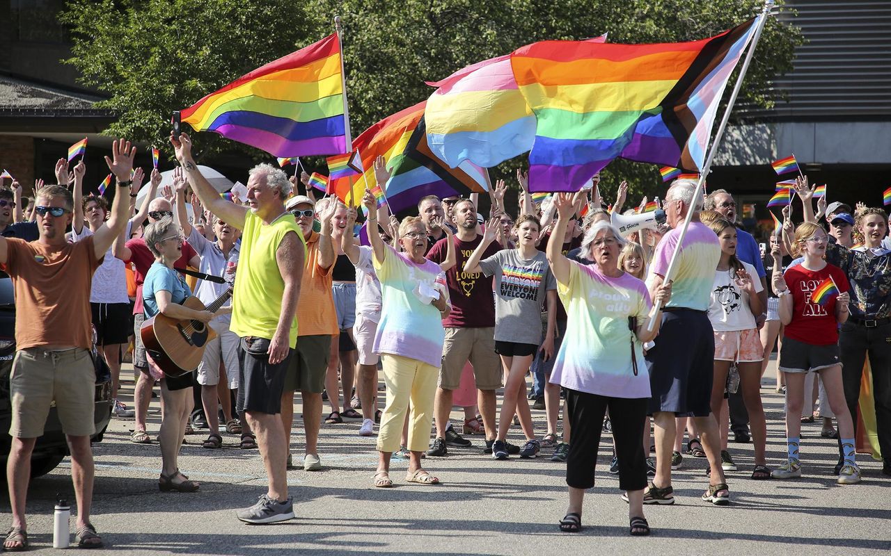 Activists for more acceptance of the LGBTQ community sing and wave flags during the Christian Reformed Church's Synod 2022, which took place on the Calvin University campus.