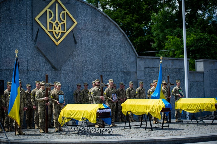 Coffins in Lviv, Ukraine are draped with Ukrainian flags as the Ukrainian Army buries with military honors three of its soldiers, each of whom died fighting invading Russian forces at frontlines across the country, on June 18.