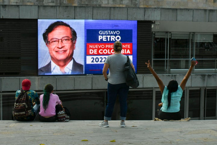 People watch a screen showing preliminary results of the presidential runoff election in Medellin, Colombia, on June 19, 2022. - Leftist ex-guerrilla Gustavo Petro took the lead over millionaire businessman rival Rodolfo Hernandez in early results of Colombia's presidential vote on Sunday, according to a live count on the Latin American country's election authority website. With 65 percent of votes counted, former mayor of Bogota Petro, 62, led by more than four points with nearly 600,000 more votes than maverick outsider Hernandez, 77. (Photo by JOAQUIN SARMIENTO / AFP) (Photo by JOAQUIN SARMIENTO/AFP via Getty Images)