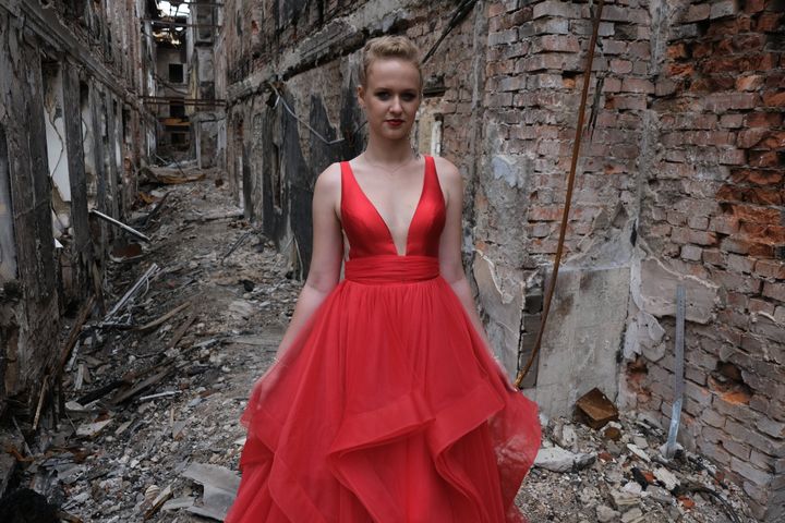 A student wearing her prom dress poses for a photo among the ruins of her school destroyed in a Russian shelling in Kharkiv, Ukraine