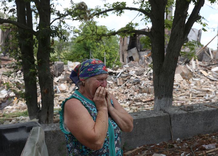 A resident reacts next to a destroyed school in the village of Bilogorivka not far from Lysychansk, Luhansk region, on June 17, 2022. 