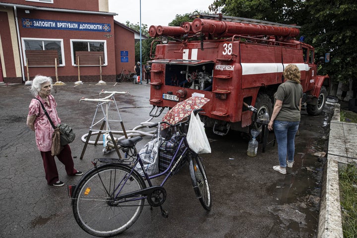 Ukrainian citizens take water from fire trucks as they try to leave the city during the evacuation operations as Russian attacks continue, on June 15, 2022 in the eastern city of Severodonetsk, Luhansk oblast, Ukraine.