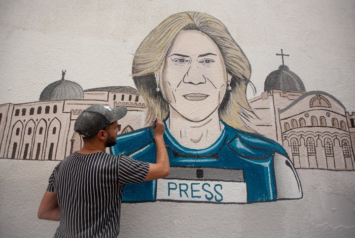 Un joven palestino pinta un mural de homenaje a Shireen Abu Akleh en Khan Yunis, Gaza.
