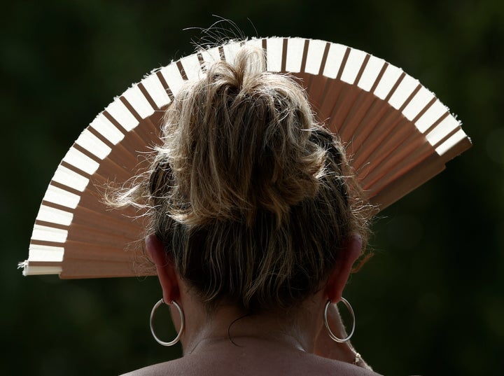 Una mujer se protege del sol con un abanico para intentar paliar el calor sofocante el viernes en Navarra.