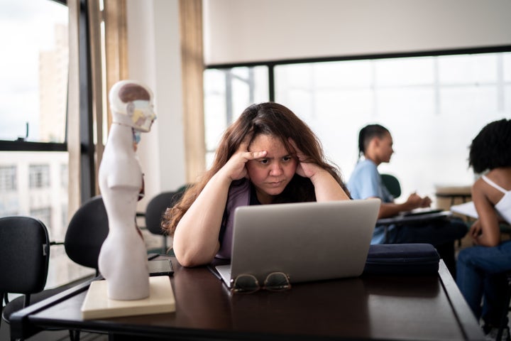 Displeased teacher working using laptop in the classroom