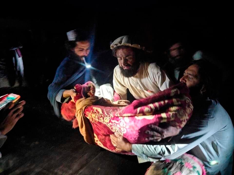 Afghans evacuate the injured from damaged homes. 