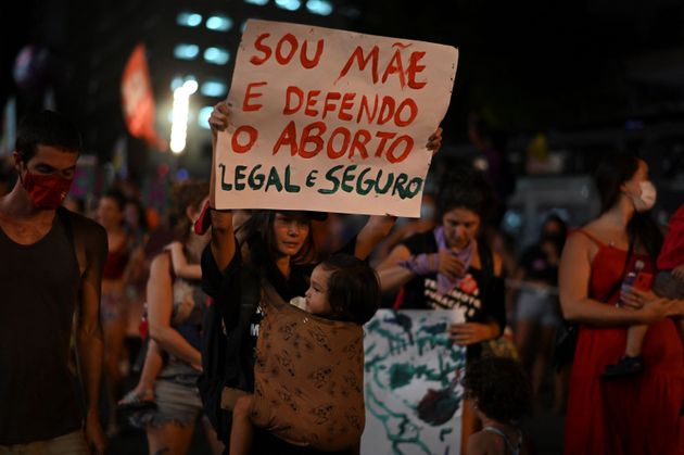 国際女性デーに合わせ、ブラジル・リオデジャネイロで行われたデモで、合法的な中絶を支持するプラカードを掲げる女性ら（2022年3月8日撮影）
