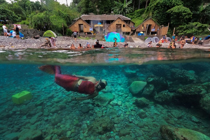 Queen Pangke Tabora swims in her mermaid suit as she conducts a mermaiding class in front of the Ocean Camp in Mabini, Batangas province, Philippines on Sunday, May 22, 2022. For the transgender Filipina woman approaching middle age, seeing her legs encased in vibrant, scaly-looking neoprene three years ago was the realization of a childhood dream. (AP Photo/Aaron Favila)