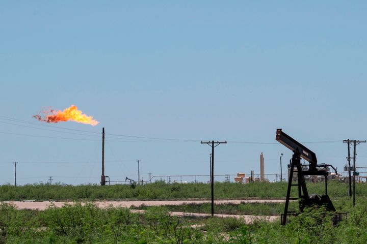 A flare stack is pictured next to pump jacks and other oil and gas infrastructure on April 24, 2020, near Odessa, Texas.