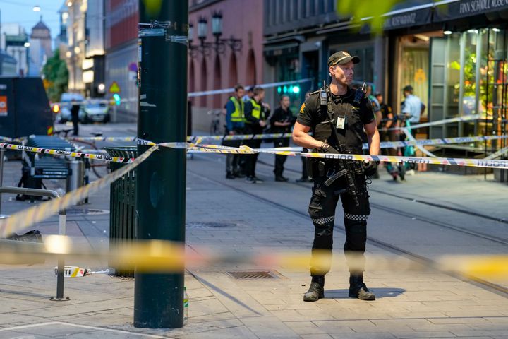 Police stand guard at the site of a mass shooting in Oslo, early Saturday, June 25, 2022.
