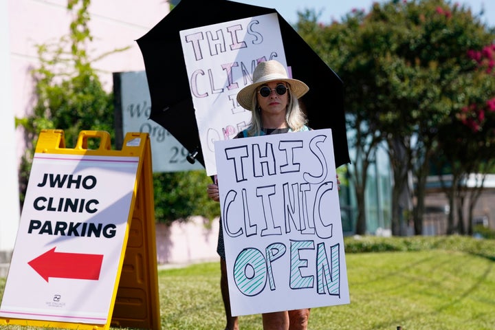 Clinic escort Libby Spence stands outside the Jackson Women's Health Organization clinic in Jackson, Miss., calling out to incoming patients that the clinic is still open, moments after the U.S. Supreme Court ruling overturning Roe v. Wade was issued, on June 24, 2022.