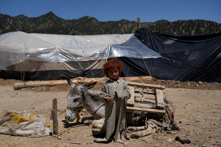 Afghan child stands in front of a makeshift shelter after an earthquake in Gayan village, in Paktika province.