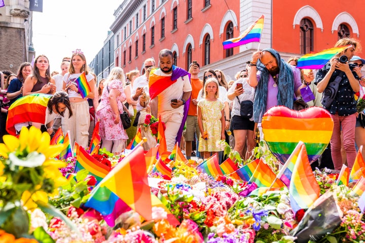 Personas frente al altar improvisado en un pub LGTBI de Oslo.