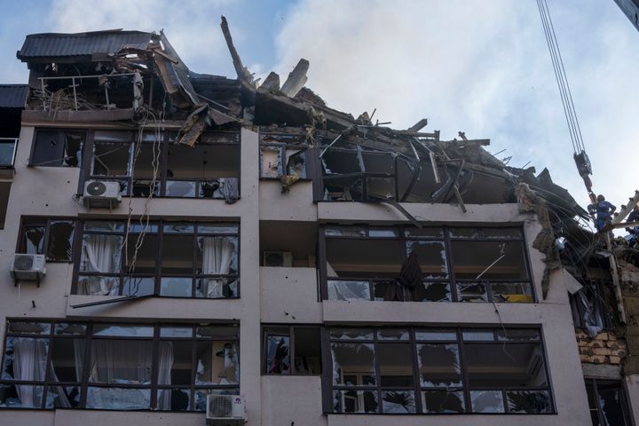 Firefighters work at the scene of a residential building following explosions, in Kyiv, Ukraine, Sunday, June 26, 2022. (AP Photo/Nariman El-Mofty)