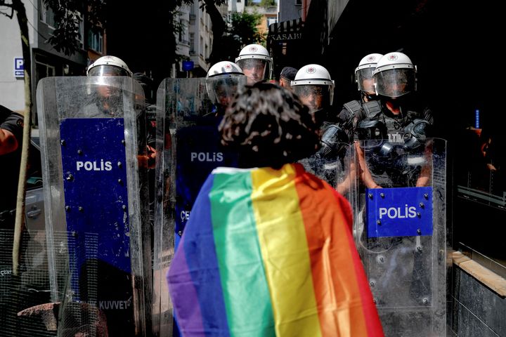 Una manifestante con la bandera LGTBI se encara a los policías turcos.