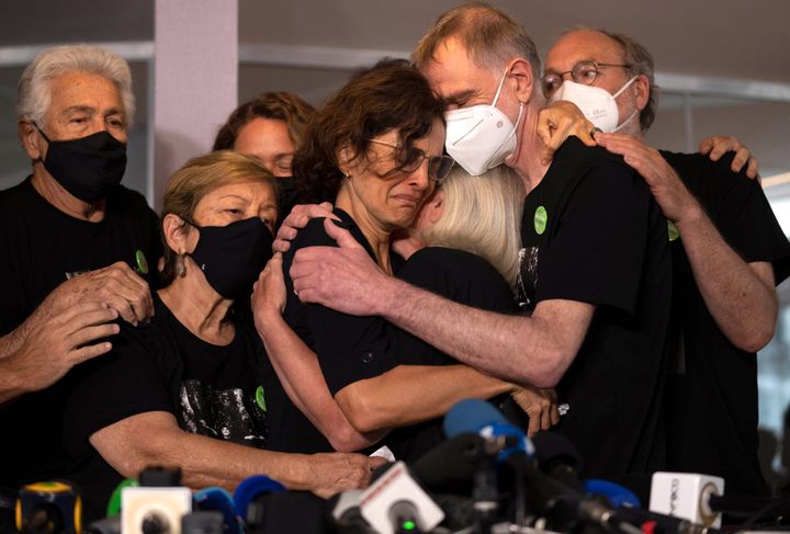 Relatives mourn as Alessandra Sampaio, center, embraces her sister-in-law Sian Phillips after speaking to the media during the funeral of her husband British journalist Dom Phillips at the Parque da Colina cemetery in Niteroi, Brazil, Sunday, June 26, 2022. Family and friends paid their final respects to Phillips who was killed in the Amazon region along with the Indigenous expert Bruno Pereira. (AP Photo/Silvia Izquierdo)
