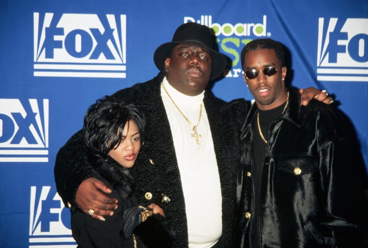 El rapero de la costa este Chris Wallace, conocido como The Notorious BIG, se interpone entre el compositor Sean "Hinchado" Combs y el rapero Little Kim en los Billboard Music Awards organizados por Fox Television.