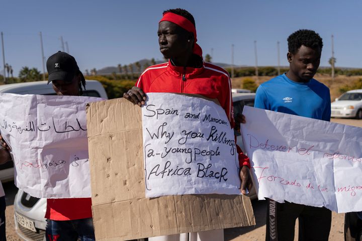 Διαδηλωτής κρατά πλακάτ που γράφει "Ισπανία και Μαρόκο, γιατί σκοτώνετε νέους μαύρους Αφρικανούς", έξω από το κέντρο βραχείας διαμονής μεταναστών CETI της Μελίγια, αφού τουλάχιστον 23 μετανάστες έχασαν τη ζωή τους προσπαθώντας να φτάσουν στον ισπανικό θύλακα, στη Μελίγια, Ισπανία, 27 Ιουνίου 2022. REUTERS/Stringer