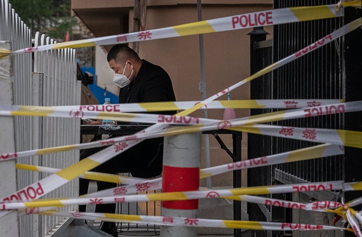 Un guardia de seguridad, tras las balizas policias que prohiben el acceso a un supermercado chino