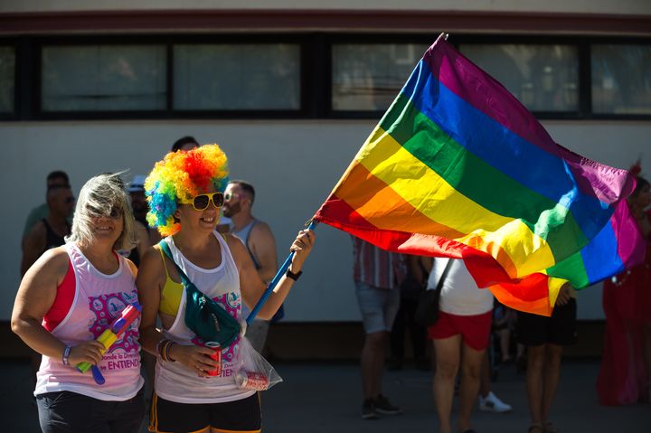 Dos mujeres ondean una bandera LGTBI en una manifestación en Málaga, el 4 de junio de 2022. 