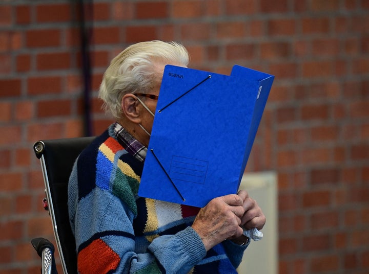 Defendant Josef S hides his face behind a folder as he arrives for his trial in northeastern Germany in 2021. The 101-year-old former concentration camp guard was convicted Tuesday of more than 3,500 counts of accessory to murder.