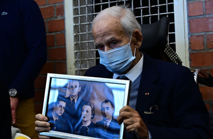 Holocaust survivor Leon Schwarzbaum shows a family picture as he arrives to observe a trial against defendant Josef S in 2021.