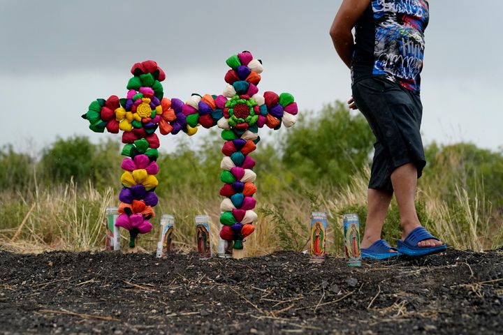 A man pays his respects Tuesday at the site where officials found dozens of people dead in a tractor-trailer containing suspected migrants near San Antonio.