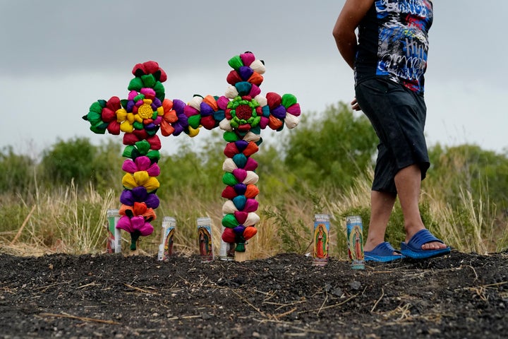 A man pays his respects Tuesday at the site where officials found dozens of people dead in a tractor-trailer containing suspected migrants near San Antonio.