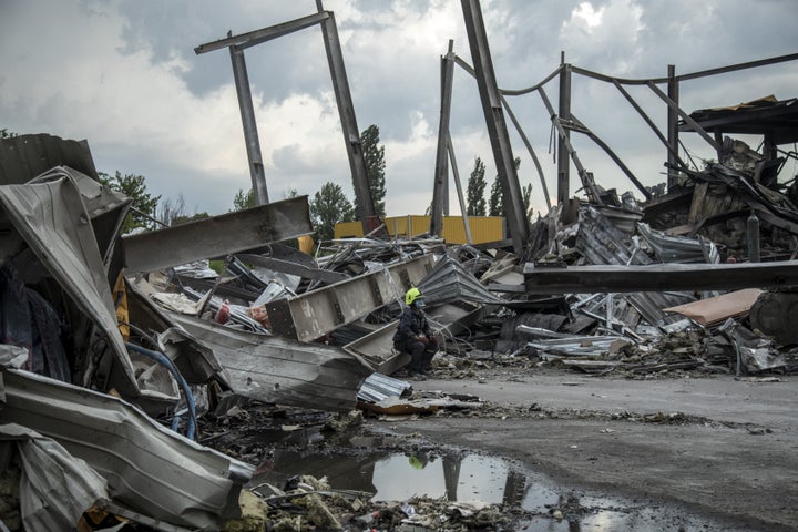 A fireman sits among the rubble of the shopping mall targeted by a Russian missile strike in Kremenchuk, Ukraine.