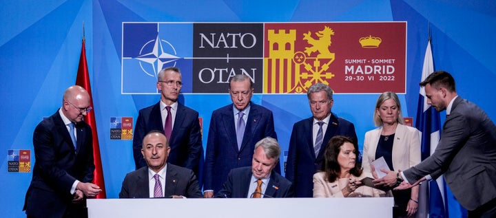 From left to right background: NATO Secretary General Jens Stoltenberg, Turkish President Recep Tayyip Erdogan, Finland's President Sauli Niinisto, Sweden's Prime Minister Magdalena Andersson, Turkish Foreign Minister Mevlut Cavusoglu, Finnish Foreign Minister Pekka Haavisto, and Sweden's Foreign Minister Ann Linde sign a memorandum in which Turkey agrees to Finland and Sweden's membership of the defense alliance in Madrid, Spain on June 28, 2022.