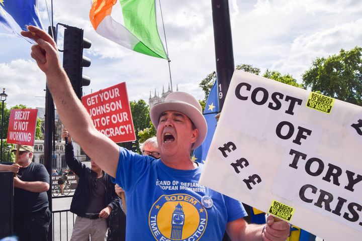 Anti-Brexit activist Steve Bray holds a placard which reads 'Cost of Tory crisis' while shouting slogans during the demonstration.