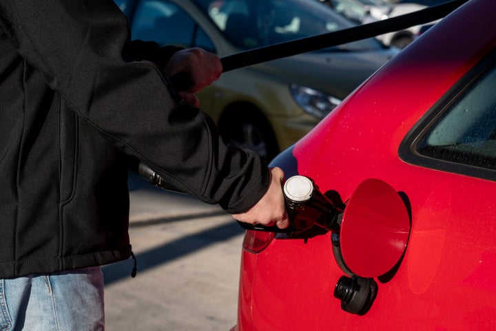 Un hombre echa combustible en su coche.