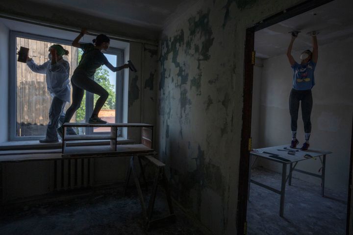 Women work to reconstruct a damaged fire department from Russian strikes, in Makariv, Kyiv region, Ukraine, on June 29, 2022. Many buildings in Makariv were destroyed or partially damaged in the first weeks of the war. 