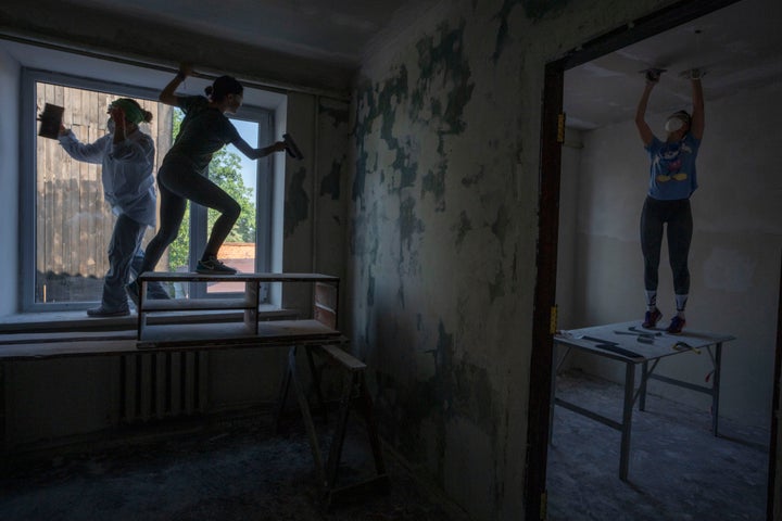 Women work to reconstruct a damaged fire department from Russian strikes, in Makariv, Kyiv region, Ukraine, on June 29, 2022. Many buildings in Makariv were destroyed or partially damaged in the first weeks of the war.