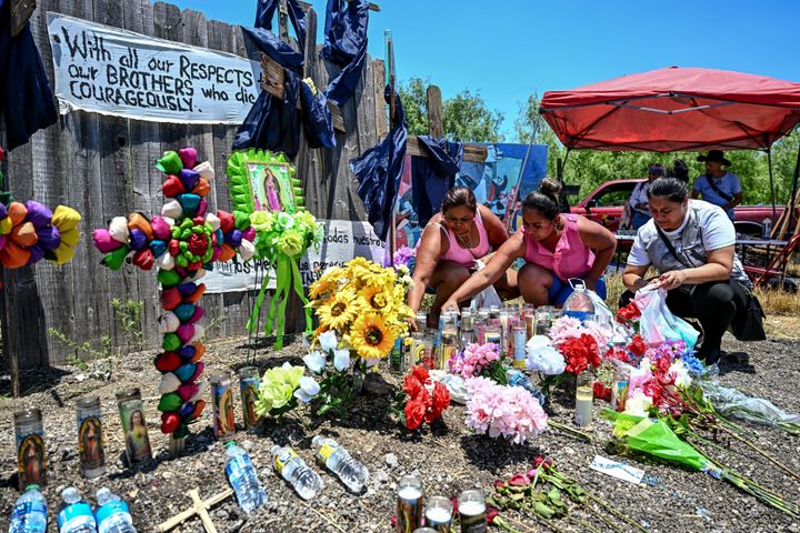 People place flowers and candles at a makeshift memorial on Wednesday where a tractor-trailer was discovered with migrants inside, outside San Antonio, Texas.