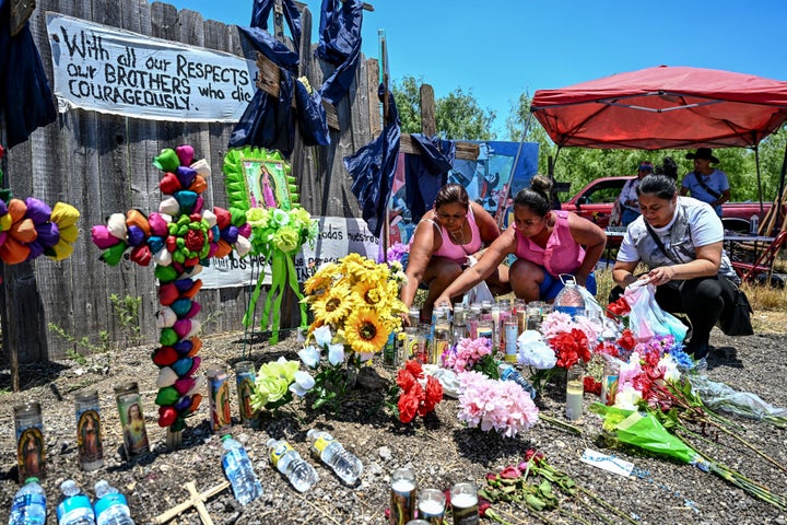 People place flowers and candles at a makeshift memorial on Wednesday where a tractor-trailer was discovered with migrants inside, outside San Antonio, Texas.