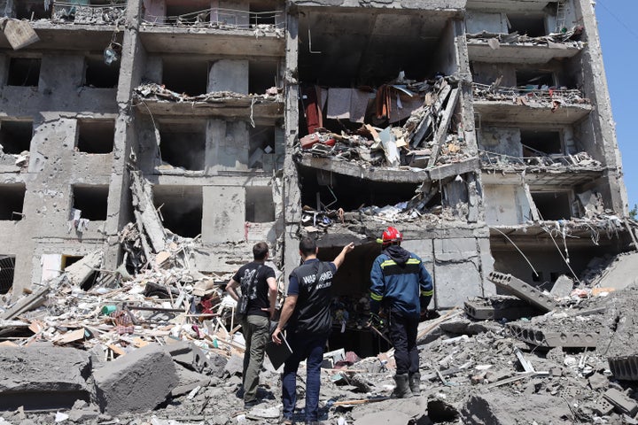 Varios operarios trabajan en el edificio destrozado por el bombardeo en Serhiivka