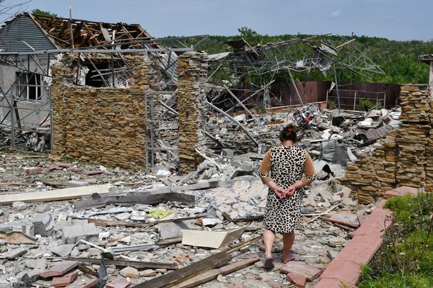Une femme âgée marche dans les décombres d'un bâtiment endommagé par...