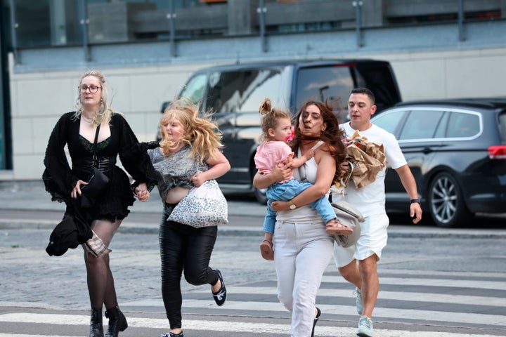 People flee the Field's shopping center after a shooting, in Copenhagen, Denmark, Sunday, July 3, 2022.