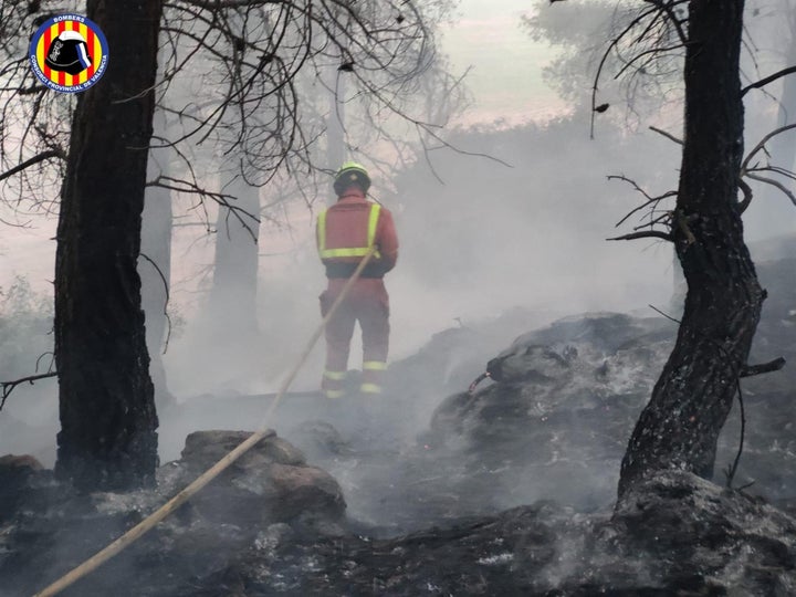 Bombero sofocando las llamas en Venta del Moro.
